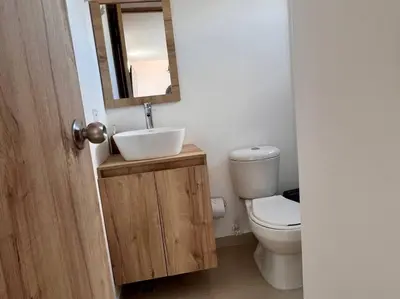 a bathroom with a toilet and a sink and a mirror at Apto Nuevo, Tranquilo a 5 min Plaza Principal in Guatapé