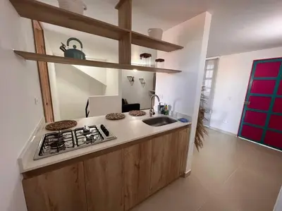 a kitchen with a stove and a sink at Apto Nuevo, Tranquilo a 5 min Plaza Principal in Guatapé