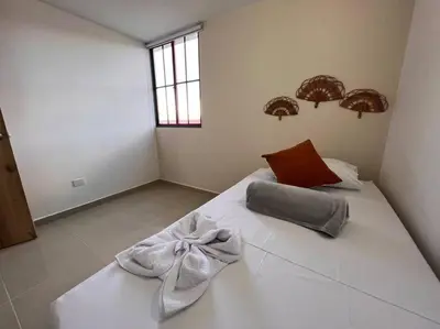 a bedroom with a white bed with a bow on it at Apto Nuevo, Tranquilo a 5 min Plaza Principal in Guatapé