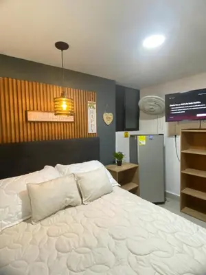 a bedroom with a large white bed and a television at HABITACIÓN independiente con COCINA EN LAURELES ESTADIO para 3 personas in Medellín