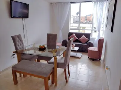a living room with a table and chairs and a couch at Lindo y acogedor apto cerca Mall Hospitales U Autónoma in Manizales