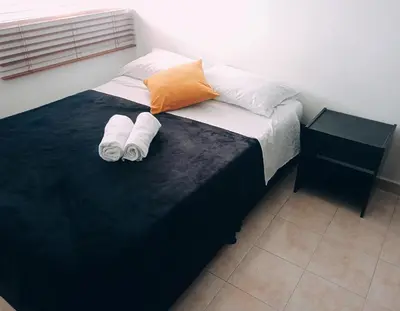 a bedroom with a bed with two towels on it at Lindo y acogedor apto cerca Mall Hospitales U Autónoma in Manizales