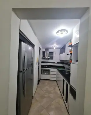 a kitchen with a stainless steel refrigerator and white cabinets at Apartamento en envigado in Envigado