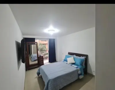 a bedroom with a bed with blue sheets and a mirror at Apartamento en envigado in Envigado