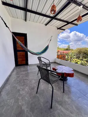 a patio with a hammock and a table and chairs at Cabaña el mirador azul in Guatapé