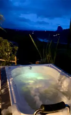 a bath tub with a view of the city at night at Cabaña el mirador azul in Guatapé