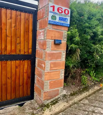 a house with a wooden gate and a sign on it at Cabaña el mirador azul in Guatapé