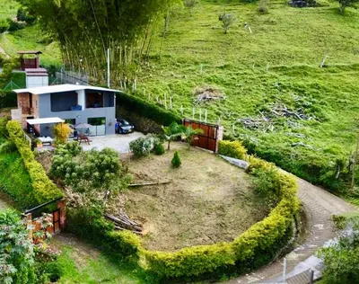 a small house in the middle of a field at Cabaña el mirador azul in Guatapé