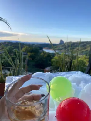a glass of water and tomatoes on a table at Cabaña el mirador azul in Guatapé