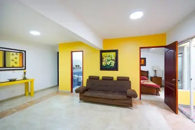 a living room with a couch and yellow walls at La Posada de Sebastian in Medellín