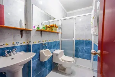 a blue and white bathroom with a toilet and a sink at La Posada de Sebastian in Medellín
