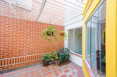 a patio with plants and a brick wall at La Posada de Sebastian in Medellín