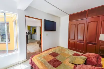 a bedroom with a bed and a flat screen tv at La Posada de Sebastian in Medellín