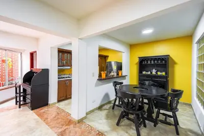 a kitchen with a table and chairs in a room at La Posada de Sebastian in Medellín