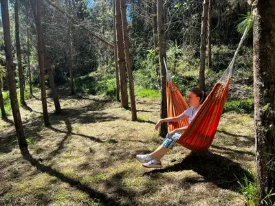 a young girl sitting in a hammock in a forest at Cabaña Luna Verde in San Vicente