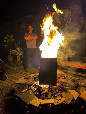 a man is standing in front of a fire at Cabaña Luna Verde in San Vicente