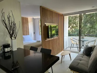 a living room with a couch and a bed and a table at Exclusivo Loft en el poblado-rodeado de naturaleza 501 in Medellín