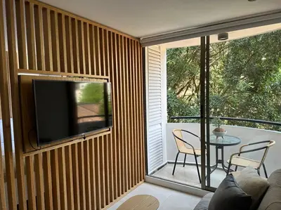 a screened in porch with a television and a table at Exclusivo Loft en el poblado-rodeado de naturaleza 501 in Medellín