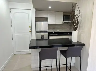 a kitchen with a black counter and two chairs at Exclusivo Loft en el poblado-rodeado de naturaleza 501 in Medellín