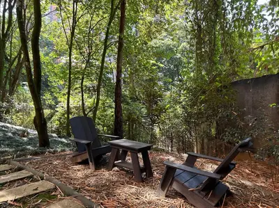 two benches and a picnic table in the woods at Exclusivo Loft en el poblado-rodeado de naturaleza 501 in Medellín