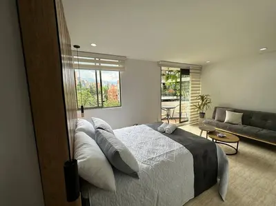 a bedroom with a bed and a living room with a couch at Nature and calm in El Poblado 505 in Medellín