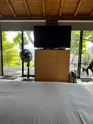 a bedroom with a television on a dresser with a fan at Loft bambu in Envigado