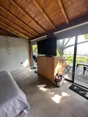 a bedroom with a bed and a flat screen tv at Loft bambu in Envigado