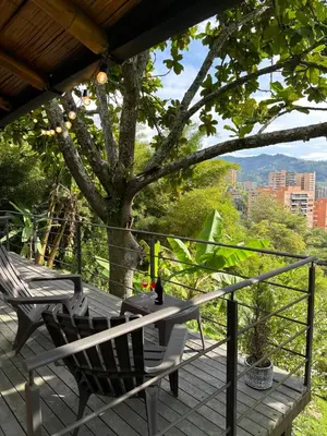 a deck with a chair and a table and a tree at Loft bambu in Envigado