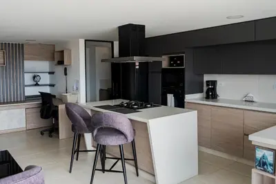 a kitchen with purple bar stools and a counter top at Apartamentos Gema Lujosos en Laureles in Medellín