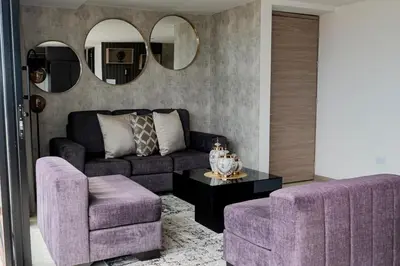 a living room with a purple couch and a table at Apartamentos Gema Lujosos en Laureles in Medellín