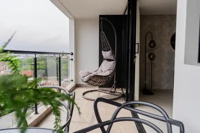 a room with a chair and a balcony at Apartamentos Gema Lujosos en Laureles in Medellín