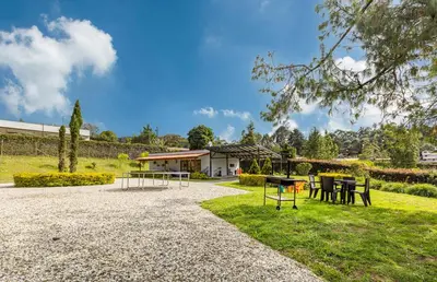 a park with tables and chairs in the grass at Buho Cabaña Santa Elena in Santa Elena