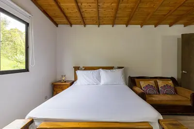 a bedroom with a large bed and a window at Buho Cabaña Santa Elena in Santa Elena