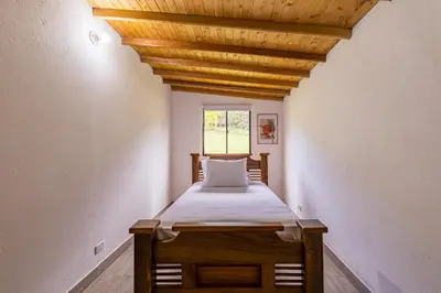 a bed in a room with a wooden ceiling at Buho Cabaña Santa Elena in Santa Elena