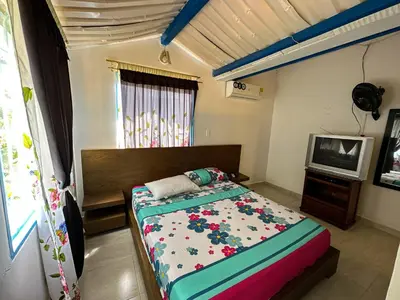 a bedroom with a bed and a tv in it at Cabaña Campestre in La Pintada