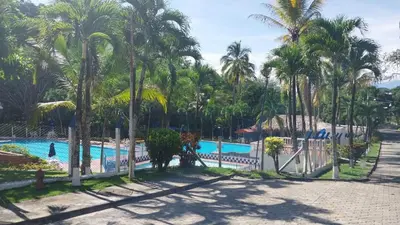a pool at a resort with palm trees at Cabaña Campestre in La Pintada