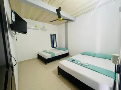 a bedroom with two beds and a flat screen tv at APARTAMENTO vista VERDE DORADAL in Doradal