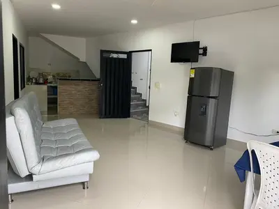 a living room with a chair and a refrigerator at APARTAMENTO EN DORADAL A 12 minutos de Nápoles in Doradal