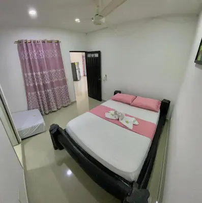 a bedroom with a bed with pink and white sheets at APARTAMENTO EN DORADAL A 12 minutos de Nápoles in Doradal