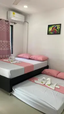 two beds in a room with pink and white at APARTAMENTO EN DORADAL A 12 minutos de Nápoles in Doradal