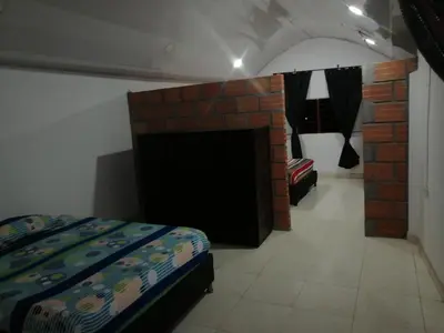 a bedroom with a bed and a brick fireplace at Casa lowcost relajación in La Dorada
