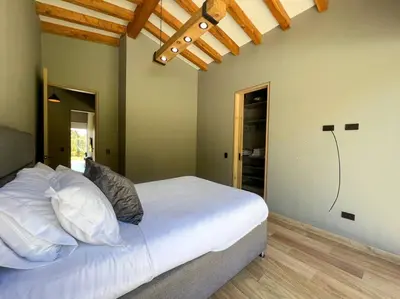 a bedroom with a bed with white sheets and pillows at Amazing country house! in Rionegro