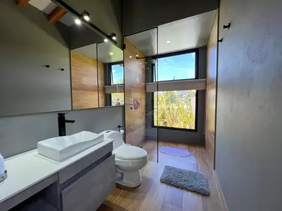 a bathroom with a toilet and a sink and a mirror at Amazing country house! in Rionegro