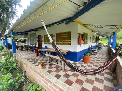 a porch with a hammock outside of a building at Hostal las Hamacas in Villamaría