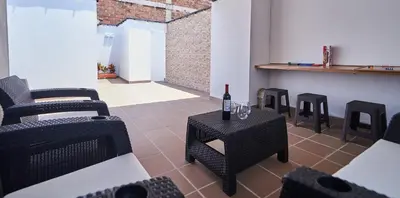 a room with a table and chairs and a bottle of wine at 5STARHOMES - Hermosa casa con terraza en Laureles in Medellín