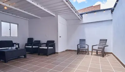 a group of chairs and tables in a room at 5STARHOMES - Hermosa casa con terraza en Laureles in Medellín