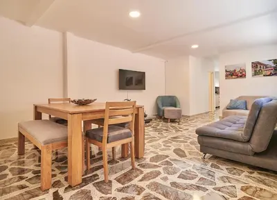 a living room with a table and chairs and a couch at 5STARHOMES - Hermosa casa con terraza en Laureles in Medellín