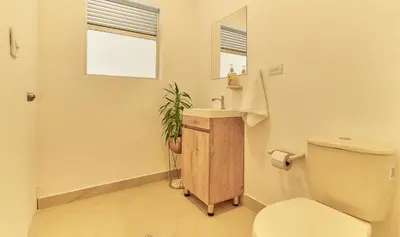 a bathroom with a toilet and a sink and a mirror at 5STARHOMES - Hermosa casa con terraza en Laureles in Medellín