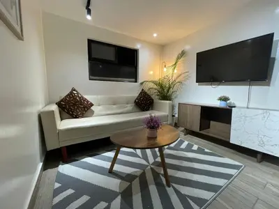 a living room with a couch and a tv at Sage house de 2 alcoba la 70 laurles estadio in Medellín