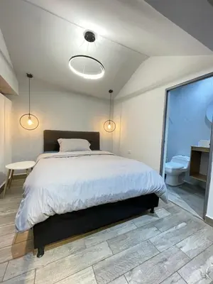 a bedroom with a large bed and a bathroom at Sage house de 2 alcoba la 70 laurles estadio in Medellín